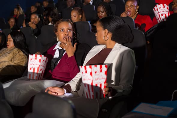 Guests watching The Devil Wears Prada 2 movie premiere with popcorn